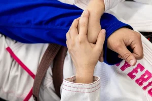 Child practicing Brazilian Jiu-Jitsu grip control during kids BJJ training, learning discipline and technique